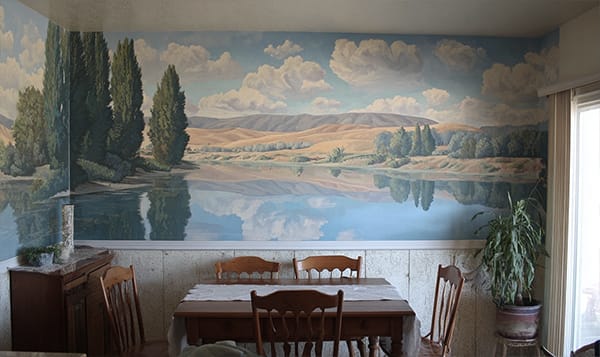 Photo of dinig room wall with mural of Tuscany painting above the chair rail
