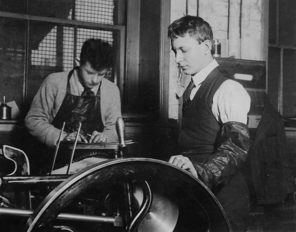 Two printers working a press